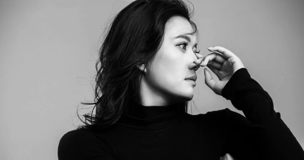 image - Tennessee Behavioral Health Woman's profile touching her nose, possibly illustrating crystal meth abuse and its physical signs.